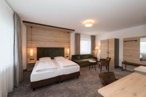a hotel room with a bed and a couch at Schneider HOTEL & APARTMENTS ALLERSBERG in Allersberg