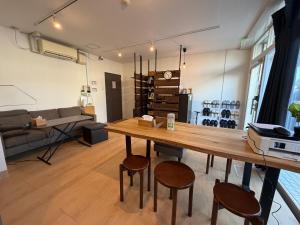 a living room with a wooden table and chairs at Fukuoka Tabiji Hostel 福岡旅路ゲストハウス in Fukuoka
