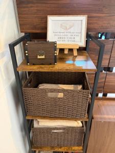 a shelf with baskets and a picture and a box at Fukuoka Tabiji Hostel 福岡旅路ゲストハウス in Fukuoka