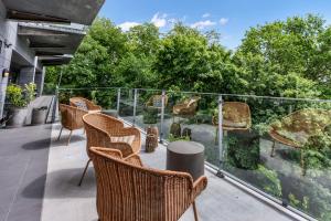 Eine Gruppe Stühle auf einem Balkon mit Bäumen in der Unterkunft Hotel Kongens Ege in Randers
