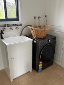 a washing machine with a basket on top of it at Oak Vue cottage in Korumburra +29 photos