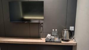 a kitchen counter with a coffee pot and water bottles at Roxy Hotel Selangau in Rumah Kudan