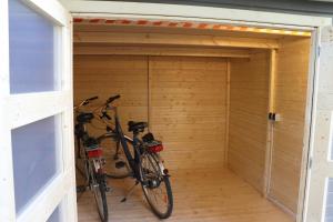 two bikes parked in a wooden garage at Ferienappartement in der Spielestadt in Ravensburg