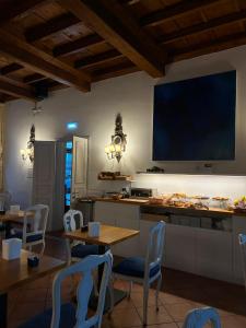 a kitchen with tables and chairs and a tv on the wall at Princess Art Hotel in Ferrara