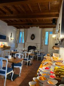 a dining room with tables and chairs with plates of food at Princess Art Hotel in Ferrara