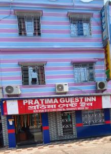 a purple building with a sign on it at Hotel Protima guest inn in Digha