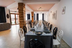 ein langes Esszimmer mit einem langen Tisch und Stühlen in der Unterkunft Abigarrado in Rucăr