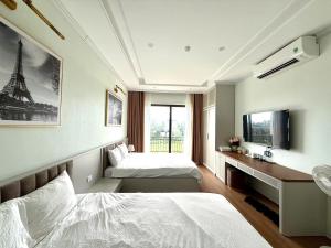 a bedroom with two beds and a desk with a tv at Huong Sky Co To in Chung Cap