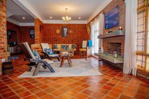 a living room with a fireplace and a brick wall at Tranquil Hillhouse in Nkoanrua