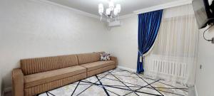 a living room with a couch and a window at Яншина 2 in Qyzylorda