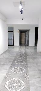 an empty room with a patterned floor and a hallway at Яншина 2 in Qyzylorda