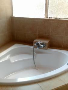 a bath tub with a water faucet in a bathroom at Natisa Lodge in Livingstone