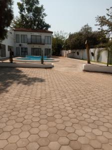 a brick courtyard with a building in the background at Natisa Lodge in Livingstone