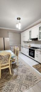 a kitchen with a table and chairs in a room at Яншина 2 in Qyzylorda