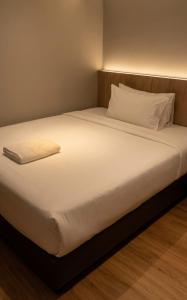 a bed with white sheets and pillows in a room at Roxy Hotel Selangau in Rumah Kudan