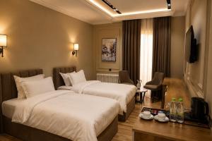 a hotel room with two beds and a television at Amanat Prestige Hotel in Samarkand