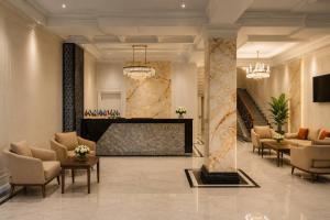 a lobby of a hotel with chairs and a fireplace at Amanat Prestige Hotel in Samarkand