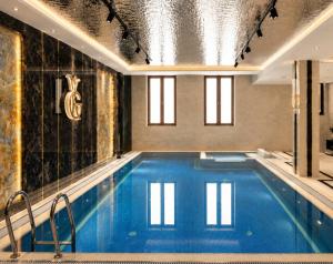 a large swimming pool with blue water in a building at Amanat Prestige Hotel in Samarkand