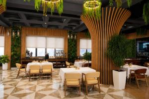 a restaurant with tables and chairs and a large column at Amanat Prestige Hotel in Samarkand