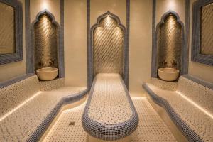a bathroom with three sinks and a row of urinals at Amanat Prestige Hotel in Samarkand +33 photos