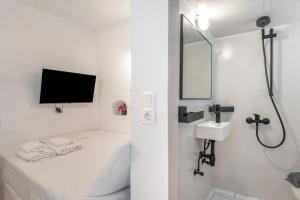 a white bathroom with a shower and a sink at Bougainvillea in Andros