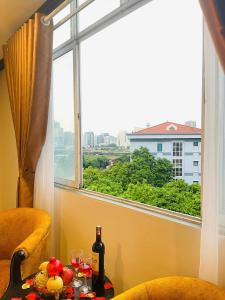 a table with a bottle of wine and a window at Vera Luxury Hotel in Hanoi