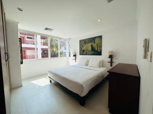 a white bedroom with a bed and a window at Surin Sabai Residence near Surin Beach in Surin Beach +31 photos