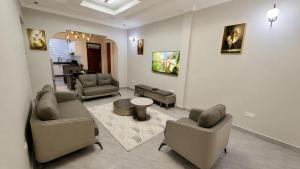 a living room with two couches and a table at Obama Apartments in Mbweni