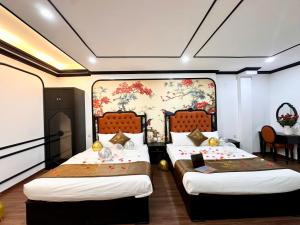 two beds in a room with a painting on the wall at Vera Luxury Hotel in Hanoi +239 photos