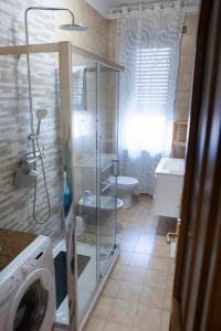 a bathroom with a shower and a toilet and a washing machine at House Santa Rita in Turin