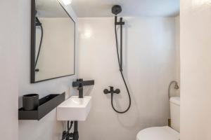 a bathroom with a toilet and a sink and a mirror at Bougainvillea in Andros +12 photos