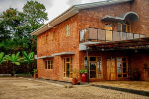 a red brick building with a balcony on it at Tranquil Hillhouse in Nkoanrua