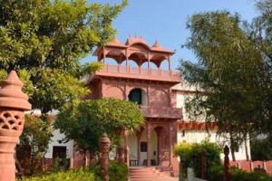 a large building with a tower on top of it at Alivaa Heritage Lotwara Fort - Near Shri Mehandipur Balaji Temple in Dausa