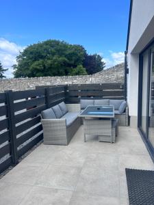a patio with a couch and a table on a building at Creagh Road House in Ballinrobe