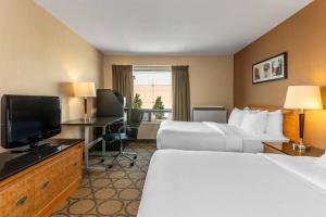 a hotel room with two beds and a flat screen tv at Comfort Inn in Brandon