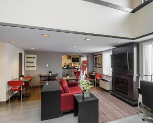 a living room with a red couch and a fireplace at Comfort Inn Prince Albert in Prince Albert