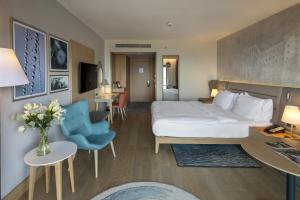 ein Hotelzimmer mit einem Bett und einer Blumenvase in der Unterkunft Radisson Blu Hotel Trabzon in Trabzon