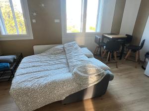a bedroom with a bed and a table and windows at horizon doux in Calais