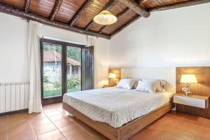 a bedroom with a bed and a large window at Refúgio da Nelinha in Rio Caldo +30 photos