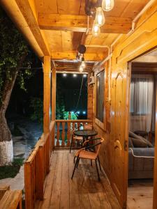 eine hölzerne Veranda mit einem Tisch und einer Couch in der Unterkunft Sabauri in Khulo