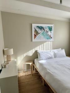 a bedroom with a white bed and a table and a lamp at Casa Piccolo - Peninsula Hot Springs 5 mins away in Rye