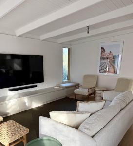a living room with white furniture and a flat screen tv at Casa Piccolo - Peninsula Hot Springs 5 mins away in Rye