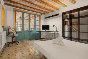 a bedroom with a bed and a desk with a computer at Casa Elegante in Vilanova i la Geltrú