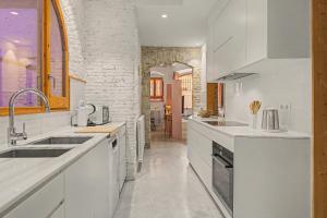 a white kitchen with a sink and a counter at Casa Elegante in Vilanova i la Geltrú