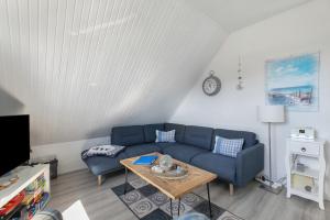 a living room with a blue couch and a table at Fewo Küstkieker in Böhl