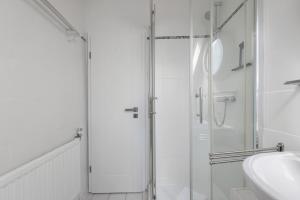 a white bathroom with a shower and a sink at Fewo Küstkieker in Böhl +19 photos
