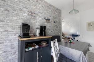 a kitchen with a table and a brick wall at Fewo Küstkieker in Böhl