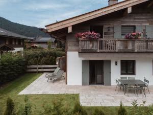 a house with a patio with a table and chairs at Egerner Chalet in Rottach-Egern
