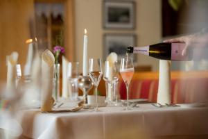 a person pouring a glass of wine on a table at Hotel Walserberg in Warth am Arlberg