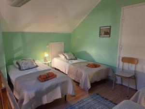 two beds in a room with green walls at Lodja Jäägrimaja in Lodja
